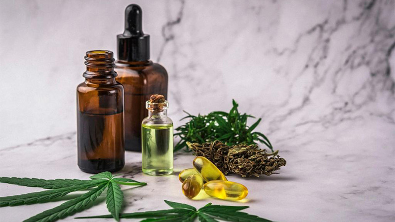 CBD oil bottles with CBD softgels and hemp leaves